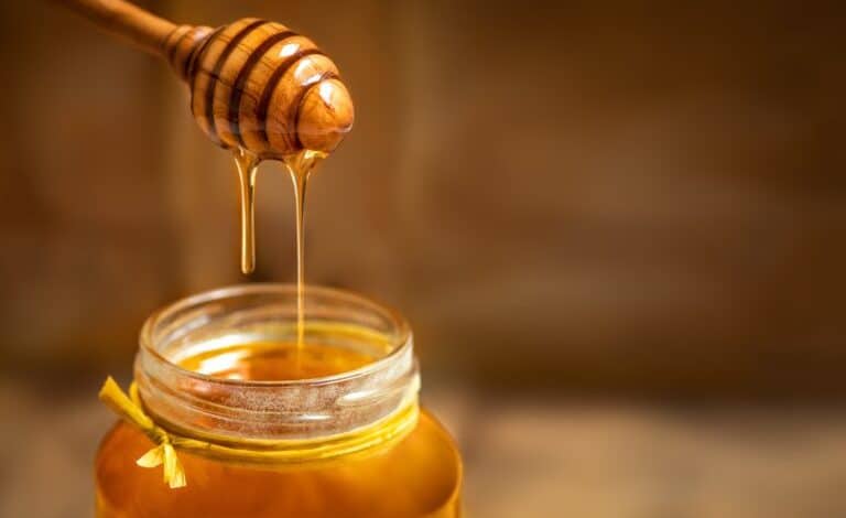 Honey in a glass jar with honey dipper 768x562 1